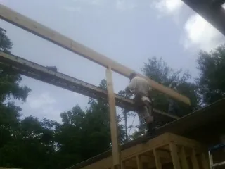 Carpenter setting a ridge beam over a new addition frame — Ice Dam Removal by Roofing Brothers in Camino