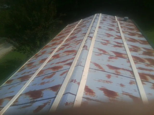 Rusted metal roof panels with new wood purlins before replacement — Storm Damage Roof Repair in Camino by Roofing Brothers