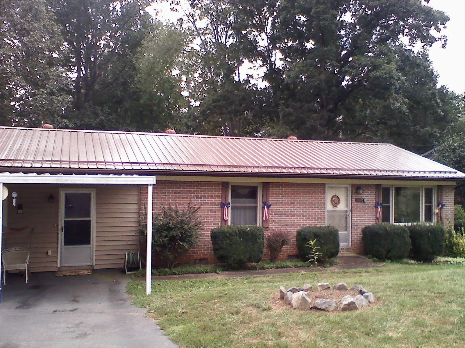 Bronze metal roof and carport on a brick ranch home — Roof Repair work by our crew in Camino